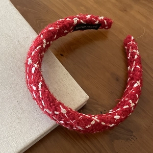 Detailed view of handmade red and white tweed headband with 'HAND MADE' inner woven label