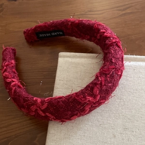 Detail of red tweed headband with handmade label and high-quality woven fabric texture
