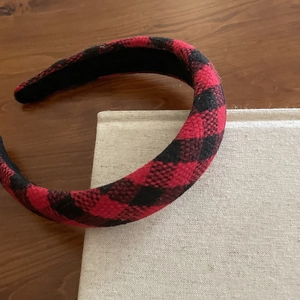 Detail of red and black buffalo check headband with thick sponge padding and fabric texture