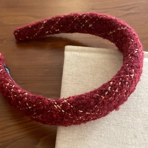 Close-up of red tweed headband with gold metallic thread and thick retro texture