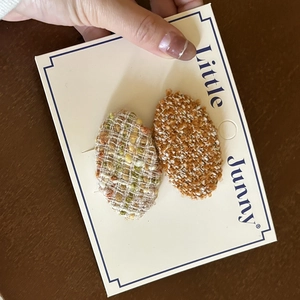 Close-up of French-style tweed wool oval BB hair clips for girls on display card