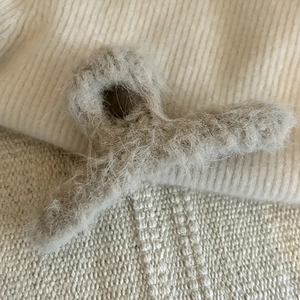 Dettaglio della morbida texture in peluche di una pinza per capelli marrone per l'inverno