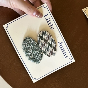 Detail of French tweed oval BB hair clips for girls showing woven texture and pattern