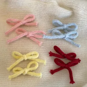 Vue détaillée de barrettes à cheveux nœuds tricotés à la main en rose, bleu, jaune et rouge