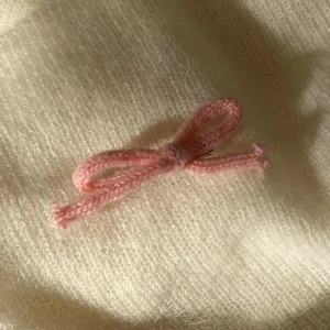 Barrette à cheveux nœud tricoté rose faite main sur tissu en peluche blanc