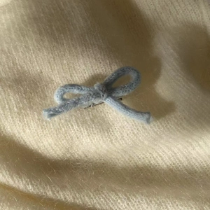 Vue rapprochée d'une pince à cheveux nœud tricoté bleu clair avec texture de laine