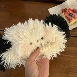 Detail of plush black and white puppy headband with soft texture and cute bead eyes