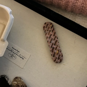 Detailed view of handmade pink tweed plaid hair clip with woven texture and premium fabric finish