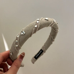 Elegant grey padded headband with sparkling crystal hearts and handmade label detail