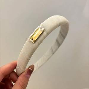 Detailed texture of ivory padded velvet headband with amber crystal embellishment