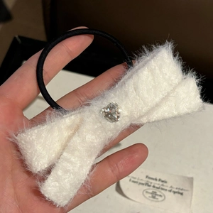 Pink heart crystal bow hair tie made of white plush faux fur on a black elastic band
