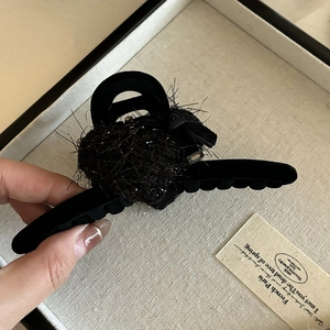 Detail showing plush black velvet hair clip with tweed heart and pearl accents