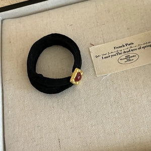 French vintage style black elastic hair tie with gold base and red oval gemstone detail