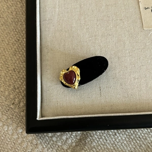 Detail of red velvet heart earring with elegant vintage gold hammered metal edges