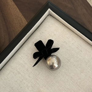 Detail einer eleganten schwarzen Samtschleife-Haarklammer mit einer polierten Silberkugel