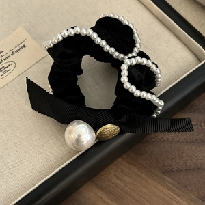 Elegant velvet hair scrunchie with pearl trim, bow, and gold button on display box