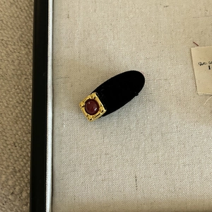 Close-up of a vintage black velvet BB clip with a gold base and dark red gemstone detail