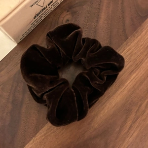 Détail d'un chouchou en velours marron café montrant la texture douce et les plis
