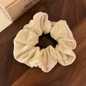 Vue détaillée du chouchou en velours crème montrant la texture douce sur bois