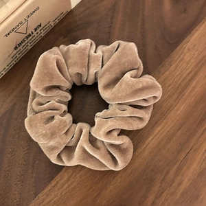 Chouchou en velours kaki sur bois foncé, accessoire plissé doux pour l'automne