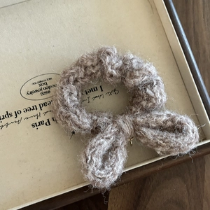Gros plan d'un chouchou en maille marron clair avec des détails de texture de nœud
