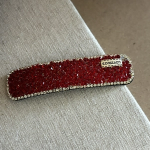 Gros plan d'une barrette à cheveux en cristal rouge avec étiquette LOVEDAYS et strass blancs