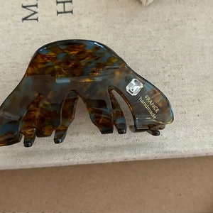 Macro shot of tortoise shell hair claw clip with rhinestone and golden France handmade text