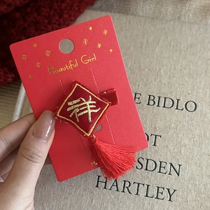 Close-up of red Chinese New Year hair clip with gold embroidery and long tassels