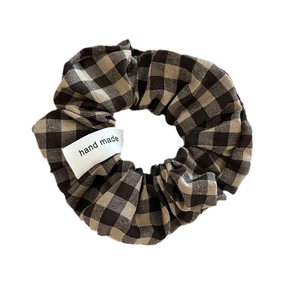 Chouchou à carreaux marron et beige avec étiquette fait main sur fond blanc
