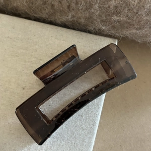Vue détaillée d'une grande pince à cheveux marron café translucide avec ressort doré