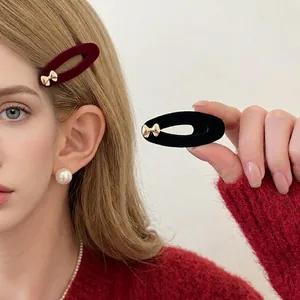 French velvet bow hair clips in black and burgundy with gold accents on model