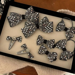 Detailset aus schwarzen Pailletten-Haarschleifen und Gummibändern mit funkelnden Strass