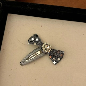 Detailansicht der schwarzen Glitzerschleife mit silbernen Pailletten und Strasssteinen