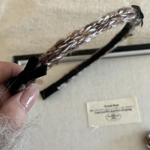 Detail of a brown and white knitted headband with black bows in French vintage style