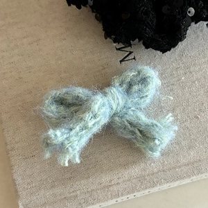 Gros plan sur la barrette nœud en mohair vert clair avec texture tricotée à la main