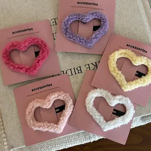 Fuzzy heart-shaped hair clips in pastel colors on decorative cards for girls