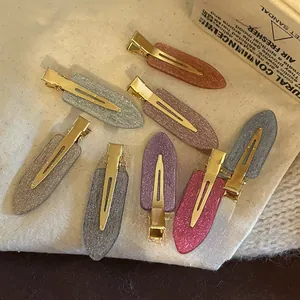 Vue détaillée de barrettes à cheveux pailletées multicolores sur tissu avec décor rétro