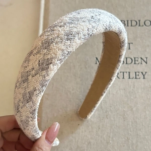 Close-up of thick pink plaid tweed headband with sponge padding and textured fabric