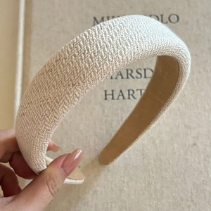 Close-up of beige woven wide headband featuring thick texture and premium inner lining