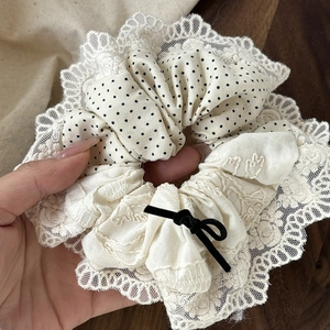 Lace scrunchie with polka dots and black velvet bow for elegant bun hairstyles