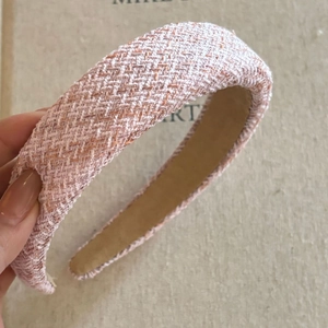 Close-up of pink tweed woven headband showing the thick texture and padded design