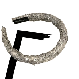 Sparkling silver velvet headband with sequins and handmade label on white background