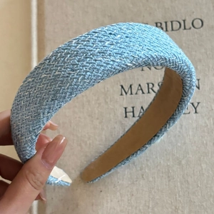 Detailed view of light blue tweed woven headband with rich textured fabric finish