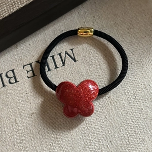 French red glitter bow hair tie with high elastic band and gold bead on linen surface