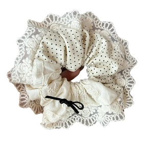 Elegant lace scrunchie with black polka dots and a delicate bow for hair styling