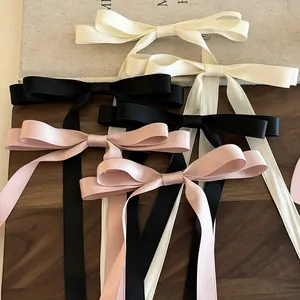 Detail von eleganten Schleifen-Haarspangen in Beige Schwarz und Rosa auf einem Tablett