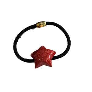 Elastic hair tie with a sparkling red glitter star charm and golden metal fastener