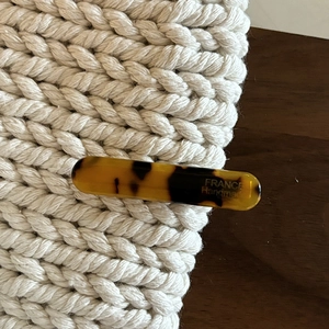 Elegant tortoiseshell acetate hair clip with handmade French craftsmanship on a textured surface