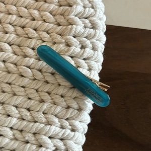 Detailed macro view of a teal acetate hair clip featuring gold FRANCE Handmade lettering