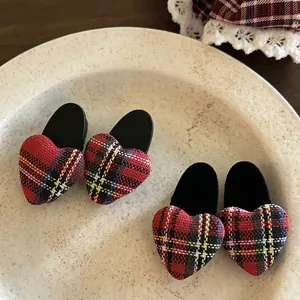 Two pairs of red plaid heart-shaped hair clips in a vintage aesthetic ceramic tray